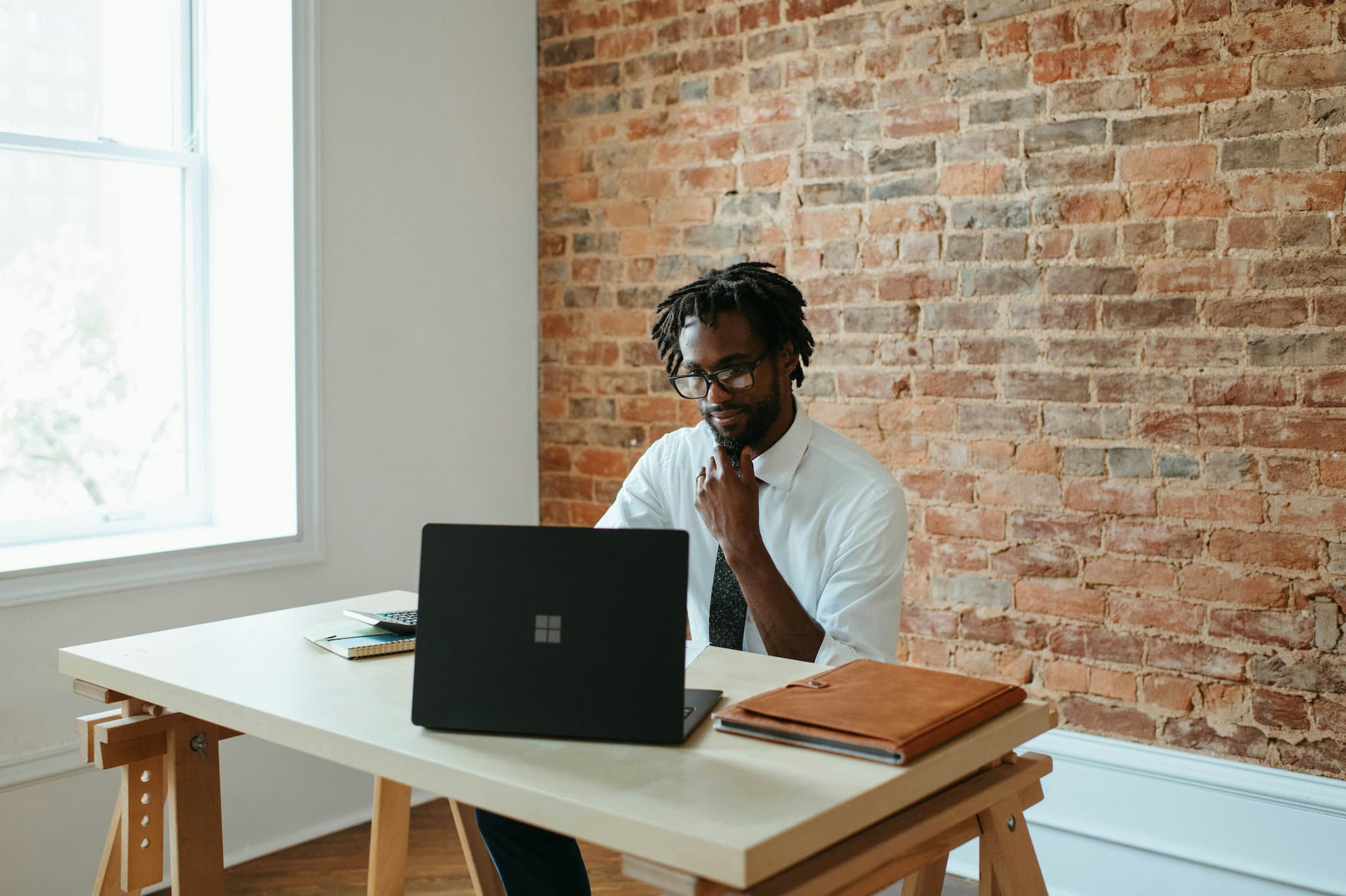 Man seated at a desk with a laptop